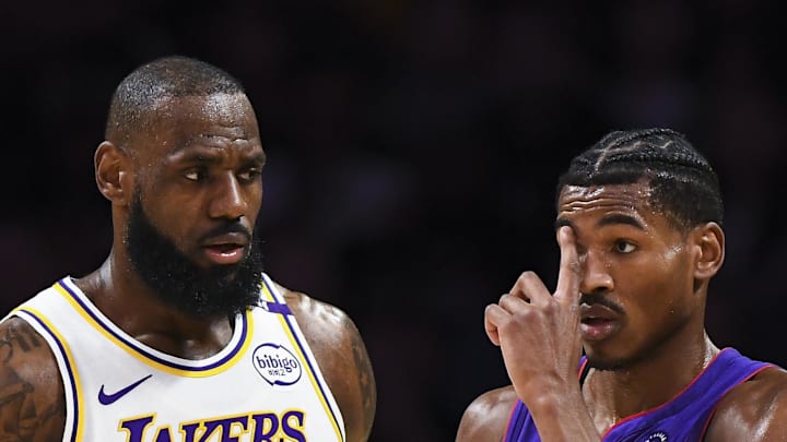 Los Angeles Lakers forward LeBron James talks to Toronto Raptors guard Ochai Agbaji.