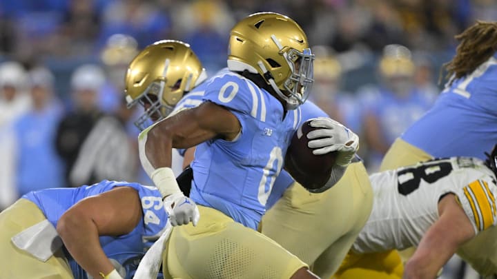 Nov 8, 2024; Pasadena, California, USA;   UCLA Bruins running back Jalen Berger (0) carries for a gain in the first half against the Iowa Hawkeyes at the Rose Bowl. Mandatory Credit: Jayne Kamin-Oncea-Imagn Images