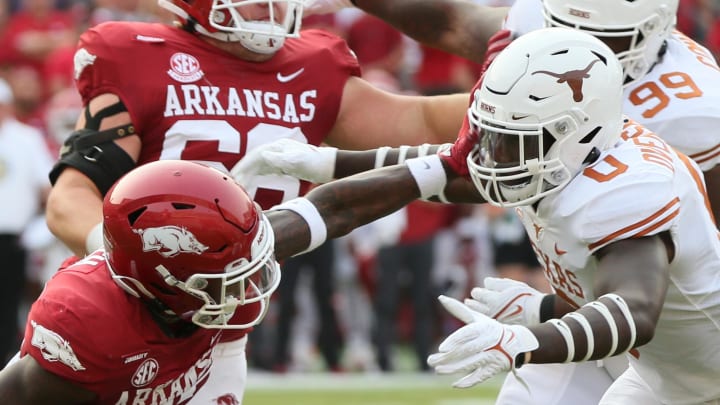 Texas Longhorns linebacker DeMarvion Overshow (0) tackles Arkansas Razorbacks running back Trelon Smith (22) during the first quarter at Razorback Stadium. Texas Longhorns linebacker DeMarvion Overshow (0) tackles Arkansas Razorbacks running back Trelon Smith (22) during the first quarter at Razorback Stadium.