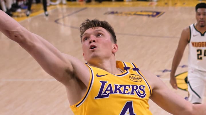 Mar 19, 2025; Los Angeles, California, USA; Denver Los Angeles Lakers guard Dalton Knecht (4) reaches for a rebound in the second half against the Denver Nuggets at Crypto.com Arena. Mandatory Credit: Jayne Kamin-Oncea-Imagn Images