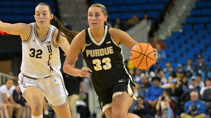 Purdue Boilermakers guard Madison Layden-Zay (33) drives past UCLA Bruins forward Angela Dugalic (32).