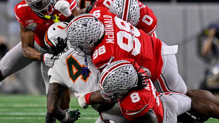 Ohio State Buckeyes linebacker Arvell Reese (8) and defensive lineman Kayden McDonald (98) (1) make the tackle 