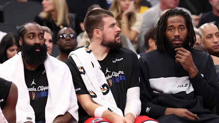 Nov 22, 2024; Inglewood, California, USA;  Los Angeles Clippers guard James Harden (1, left) and center Ivica Zubac (40, center) and Kawhi Leonard (right) watch a game from the bench during the second half against the Sacramento Kings at Intuit Dome. Mandatory Credit: Kiyoshi Mio-Imagn Images