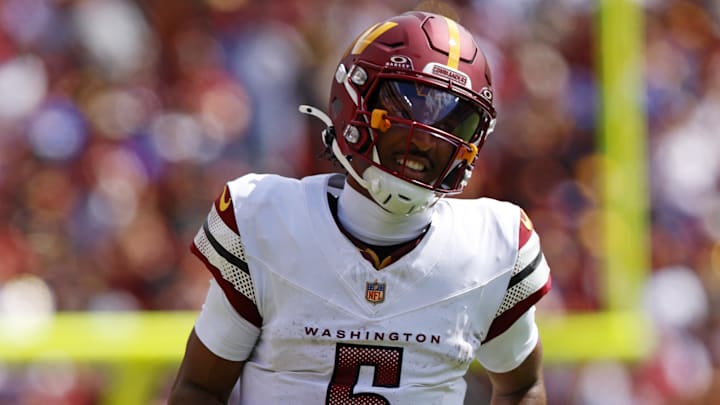 Sep 7, 2025; Landover, Maryland, USA; Washington Commanders quarterback Jayden Daniels (5) runs the ball against New York Giants linebacker Brian Burns (0) during the second quarter at Northwest Stadium. Mandatory Credit: Peter Casey-Imagn Images