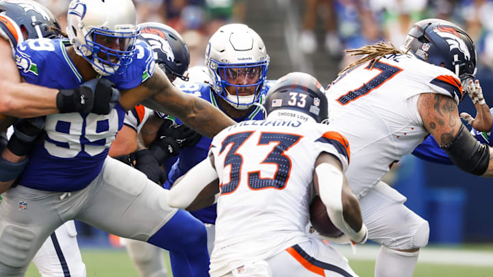 Sep 8, 2024; Seattle, Washington, USA; Seattle Seahawks defensive tackle Byron Murphy II (91) tackles Denver Broncos running back Javonte Williams (33) for a loss during the fourth quarter at Lumen Field. Mandatory Credit: Joe Nicholson-Imagn Images