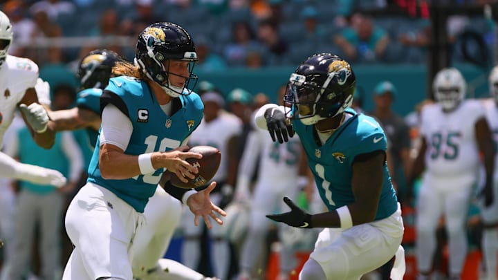 Sep 8, 2024; Miami Gardens, Florida, USA; Jacksonville Jaguars running back Travis Etienne Jr. (1) takes a handoff from quarterback Trevor Lawrence (16) against the Miami Dolphins during the first quarter  at Hard Rock Stadium. Mandatory Credit: Sam Navarro-Imagn Images
