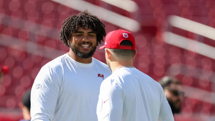 Tampa Bay Buccaneers offensive tackle Tristan Wirfs and quarterback Baker Mayfield warm up before a game.