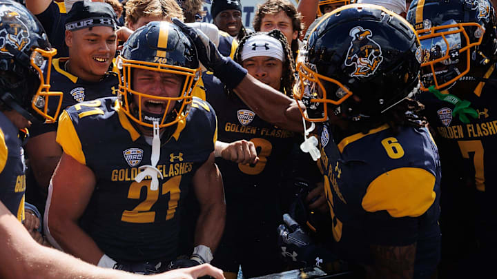 Kent State running back Cade Wolford rings the Victory Bell surrounded by his teammates after the Golden Flashes won their season opener over Merrimack College on Aug. 30, 2025, in Kent.