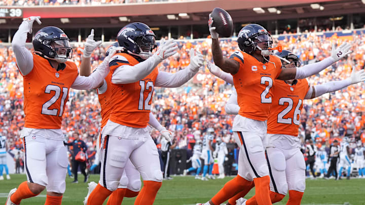 Oct 27, 2024; Denver, Colorado, USA; Denver Broncos cornerback Pat Surtain II (2) celebrates his interception with cornerback Riley Moss (21) and linebacker Kwon Alexander (12) and safety Devon Key (26) in the third quarter against the Carolina Panthers at Empower Field at Mile High. 