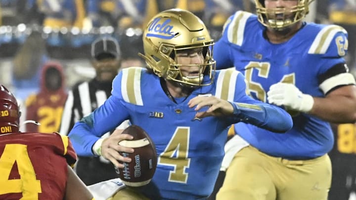 Nov 23, 2024; Pasadena, California, USA; UCLA Bruins quarterback Ethan Garbers (4) runs past USC Trojans linebacker Easton Mascarenas-Arnold (4) during the third quarter at Rose Bowl. Mandatory Credit: Robert Hanashiro-Imagn Images
