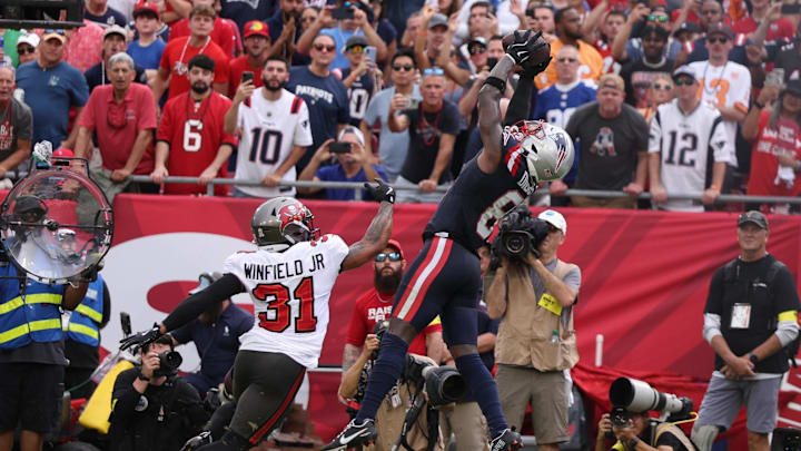 Nov 9, 2025; Tampa, Florida, USA; New England Patriots wide receiver Stefon Diggs (8) catches a touchdown pass under pressure from Tampa Bay Buccaneers safety Antoine Winfield Jr. (31) during the second quarter at Raymond James Stadium. Mandatory Credit: Nathan Ray Seebeck-Imagn Images