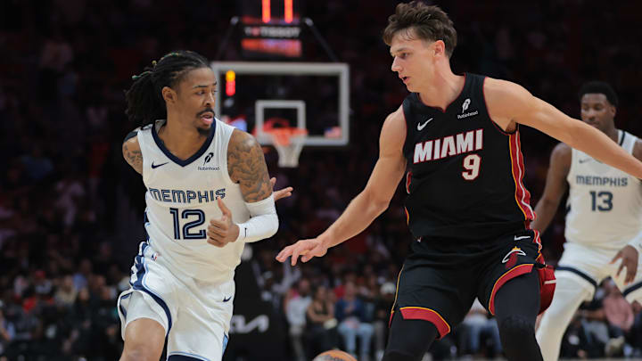Apr 3, 2025; Miami, Florida, USA; Memphis Grizzlies guard Ja Morant (12) passes the basketball as Miami Heat guard Pelle Larsson (9) defends during the second quarter at Kaseya Center. Mandatory Credit: Sam Navarro-Imagn Images