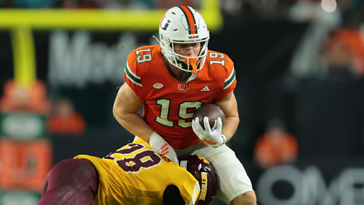 Sep 6, 2025; Miami Gardens, Florida, USA; Miami Hurricanes tight end Brock Schott (19) runs with the football against Bethune-Cookman Wildcats safety Jaden Davis (28) during the fourth quarter at Hard Rock Stadium.