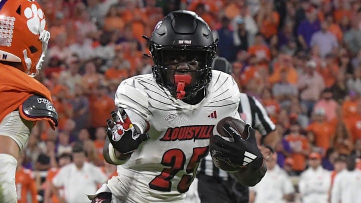Nov 2, 2024; Clemson, South Carolina, USA; Louisville Cardinals running back Isaac Brown (25) runs the ball against Clemson Tigers cornerback Jeadyn Lukus (10) during the second quarter at Memorial Stadium. 