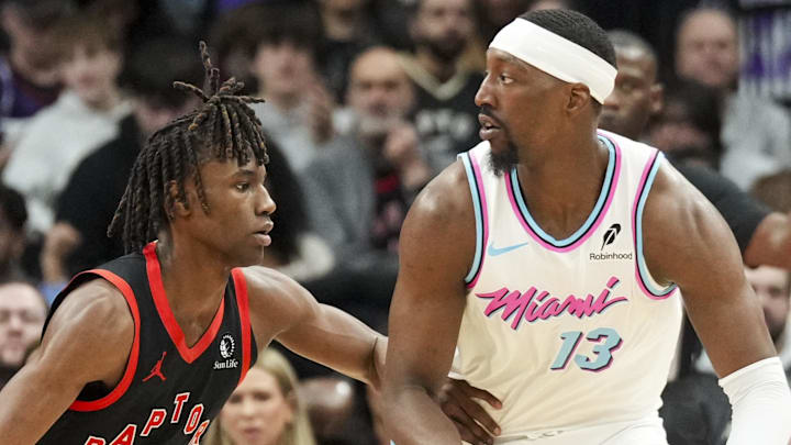 Miami Heat center Bam Adebayo dribbles the ball against Toronto Raptors guard Ja'Kobe Walter.