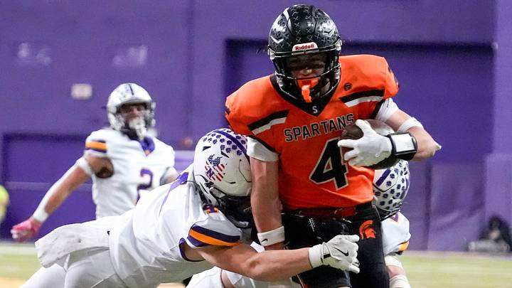 Solon wide receiver Maddox Kelley (4) is tackled by Nevada safety Isaac Williams (4) and Nevada linebacker Austin Waldera (21) Nov. 15, 2025 during a Class 3A Iowa high school football semifinal at the UNI-Dome in Cedar Falls, Iowa. Solon wide receiver Maddox Kelley (4) is tackled by Nevada safety Isaac Williams (4) and Nevada linebacker Austin Waldera (21) Nov. 15, 2025 during a Class 3A Iowa high school football semifinal at the UNI-Dome in Cedar Falls, Iowa.