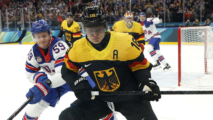 Feb 15, 2026; Milan, Italy; Tim Stutzle of Germany in action with Jake Guentzel of United States in men's ice hockey group C play during the Milano Cortina 2026 Olympic Winter Games at Milano Santagiulia Ice Hockey Arena. Mandatory Credit: Geoff Burke-Imagn Images