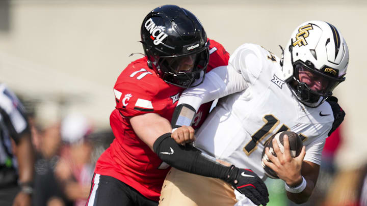 Cincinnati Bearcats linebacker Jake Golday (11) attempts to tackle UCF Knights quarterback Cam Fancher (14) in the second half at Nippert Stadium. Cincinnati Bearcats linebacker Jake Golday (11) attempts to tackle UCF Knights quarterback Cam Fancher (14) in the second half at Nippert Stadium.