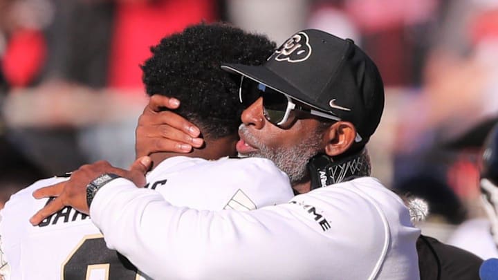 Colorado football coach Deion Sanders hugs his son, Shedeur Sanders, before facing Texas Tech in a Big 12 football game Saturday, Nov. 9, 2024, at Jones AT&T Stadium.