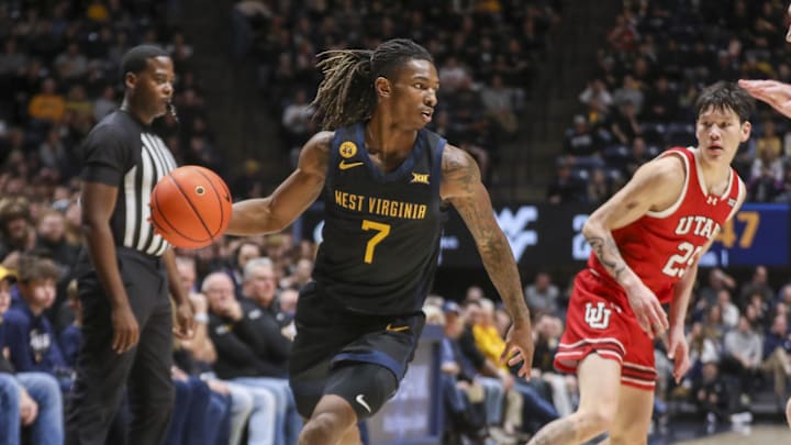 Feb 8, 2025; Morgantown, West Virginia, USA; West Virginia Mountaineers guard Javon Small (7) dribbles around Utah Utes defenders during the first half at WVU Coliseum. Mandatory Credit: Ben Queen-Imagn Images
