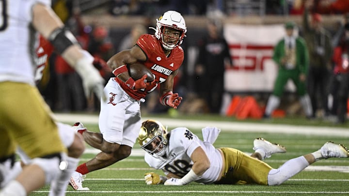 Oct 7, 2023; Louisville, Kentucky, USA; Louisville Cardinals defensive back Devin Neal (27) returns an interception past Notre Dame Fighting Irish tight end Mitchell Evans (88) during the second half at L&N Federal Credit Union Stadium. Louisville defeated Notre Dame 33-20. Mandatory Credit: Jamie Rhodes-Imagn Images