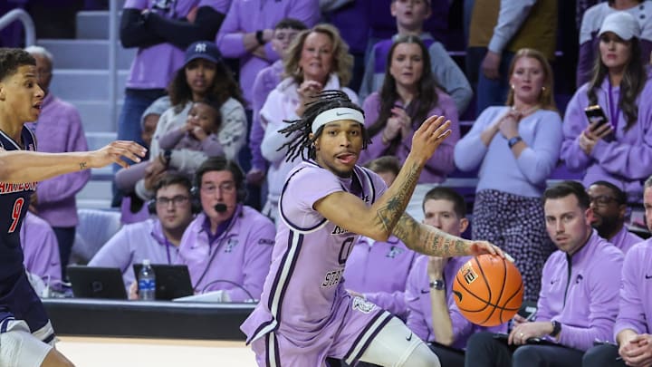 Feb 11, 2025; Manhattan, Kansas, USA; Kansas State Wildcats guard Dug McDaniel (0) dribbles away from Arizona Wildcats forward Carter Bryant (9) during the second half at Bramlage Coliseum. Mandatory Credit: Scott Sewell-Imagn Images