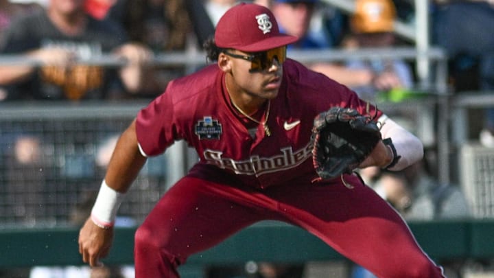 Jun 14, 2024; Omaha, NE, USA;  Tennessee Volunteers second baseman Christian Moore (1) slides into third base with a triple against Florida State Seminoles third baseman Cam Smith (24) during the first inning at Charles Schwab Filed Omaha