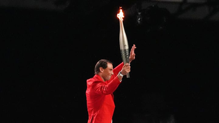 Rafael Nadal holds the Olympic torch during the Opening Ceremony for the Paris 2024 Olympic Summer Games.