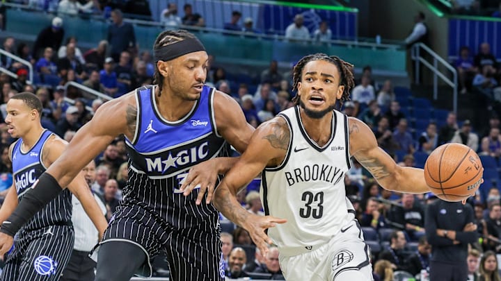 Nov 14, 2025; Orlando, Florida, USA; Brooklyn Nets center Nic Claxton (33) drives to the basket around Orlando Magic center Wendell Carter Jr. (34) during the first quarter at Kia Center. Mandatory Credit: Mike Watters-Imagn Images