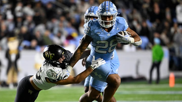 Nov 16, 2024; Chapel Hill, North Carolina, USA; North Carolina Tar Heels running back Omarion Hampton (28) runs as Wake Forest Demon Deacons defensive back Nick Andersen (45) defends in the third quarter at Kenan Memorial Stadium. Nov 16, 2024; Chapel Hill, North Carolina, USA; North Carolina Tar Heels running back Omarion Hampton (28) runs as Wake Forest Demon Deacons defensive back Nick Andersen (45) defends in the third quarter at Kenan Memorial Stadium.