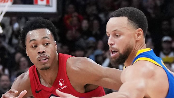 Golden State Warriors guard Stephen Curry battles for the ball with Toronto Raptors forward Scottie Barnes.