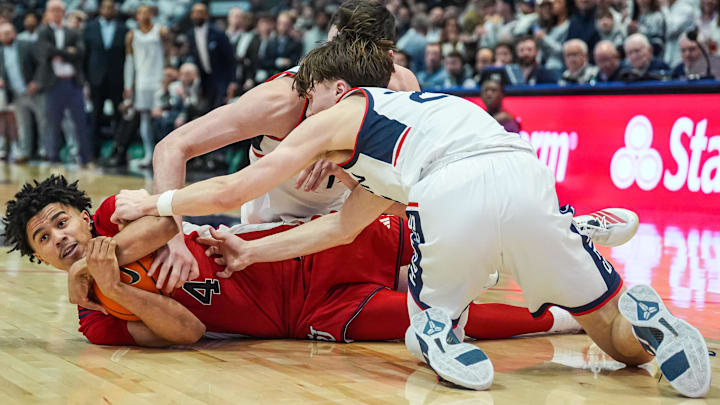 Feb 25, 2026; Hartford, Connecticut, USA; St. John's Red Storm guard Oziyah Sellers (4) works for the ball against UConn Huskies forward Alex Karaban (11) and guard Braylon Mullins (24) in the second half at PeoplesBank Arena. Mandatory Credit: David Butler II-Imagn Images