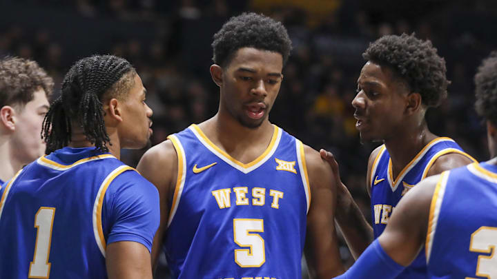 Jan 31, 2026; Morgantown, West Virginia, USA; West Virginia Mountaineers forward DJ Thomas (5) celebrates with teammates during the first half against the Baylor Bears at Hope Coliseum. Mandatory Credit: Ben Queen-Imagn Images