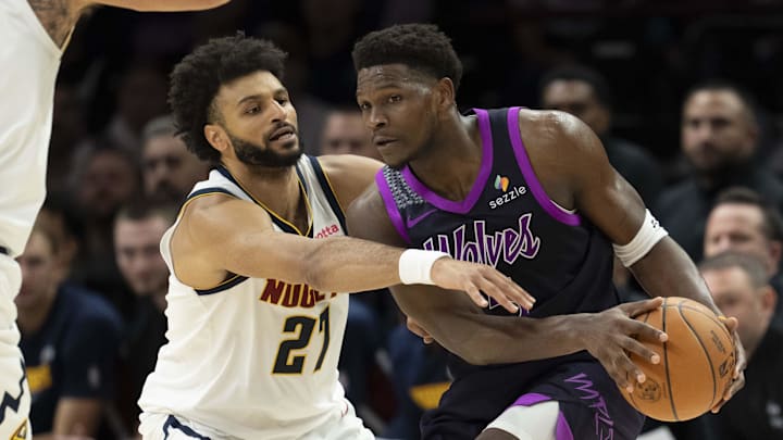 Nov 15, 2025; Minneapolis, Minnesota, USA; Minnesota Timberwolves guard Anthony Edwards (5) dribbles the ball as Denver Nuggets guard Jamal Murray (27) plays defense in the second half at Target Center.