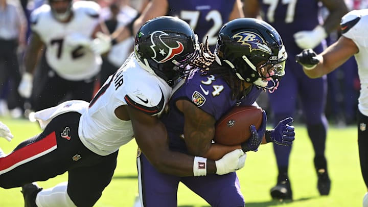 Baltimore Ravens running back Keaton Mitchell is tackled by Houston Texans linebacker Azeez al-Shaair.
