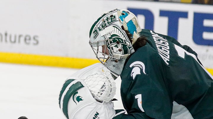 Michigan State goaltender Trey Augustine makes a save against Michigan right wing Gavin Brindley during the third period at Yost Ice Arena in Ann Arbor on Friday, Feb. 9, 2024. Michigan State goaltender Trey Augustine makes a save against Michigan right wing Gavin Brindley during the third period at Yost Ice Arena in Ann Arbor on Friday, Feb. 9, 2024.