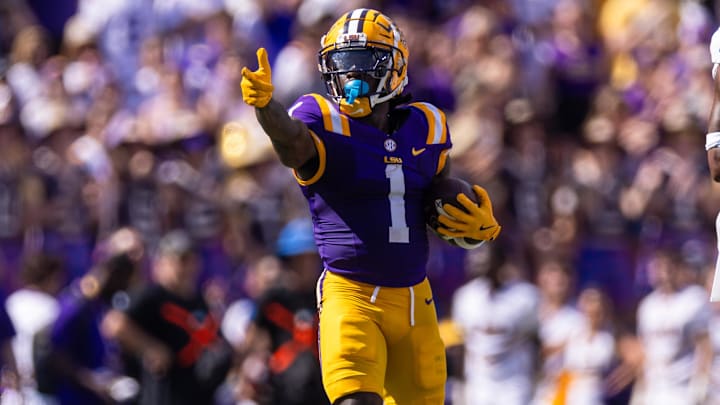 Sep 21, 2024; Baton Rouge, Louisiana, USA;  LSU Tigers wide receiver Aaron Anderson (1) reacts after making a first down against UCLA Bruins defensive back K.J. Wallace (7) during the first half at Tiger Stadium. Mandatory Credit: Stephen Lew-Imagn Images
