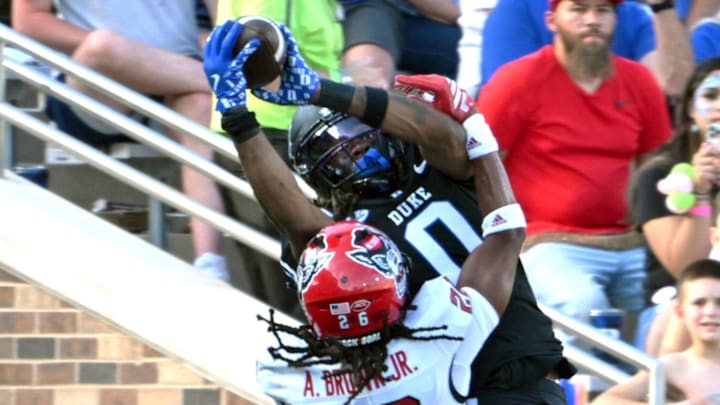 Sep 20, 2025; Durham, North Carolina, USA;  Duke Blue Devils cornerback Chandler Rivers (0) catches a touchdown pass against North Carolina State Wolfpack defensive back Asaad Brown Jr. (26) during the second quarter at Wallace Wade Stadium. Mandatory Credit: Zachary Taft-Imagn Images
