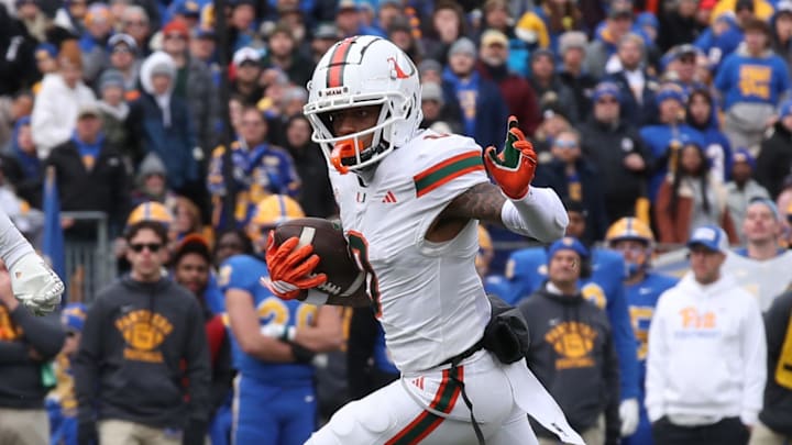 Nov 29, 2025; Pittsburgh, Pennsylvania, USA;  Miami Hurricanes wide receiver Keelan Marion (0) runs after a catch as Pittsburgh Panthers linebacker Kyle Louis (9) pursues during the first quarter at Acrisure Stadium. Mandatory Credit: Charles LeClaire-Imagn Images