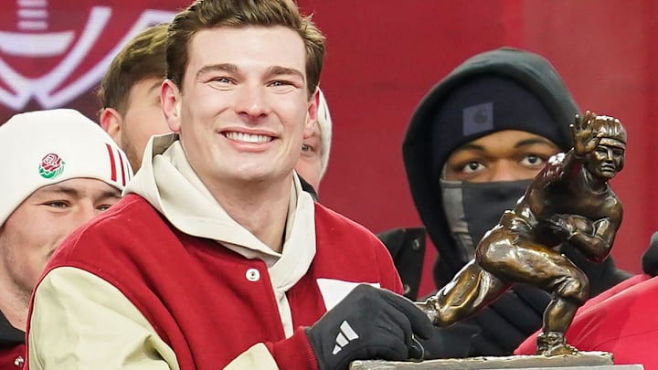Indiana Hoosiers quarterback Fernando Mendoza (15) holds the Heisman Trophy with Indiana Hoosiers head coach Curt Cignetti on Saturday, Jan. 24, 2026, during the Indiana Football College Football Playoff National Championship celebration and parade at Memorial Stadium in Bloomington.