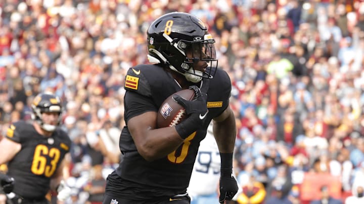 Dec 1, 2024; Landover, Maryland, USA; Washington Commanders running back Brian Robinson Jr. (8) carries the ball to score a touchdown against the Tennessee Titans during the first half at Northwest Stadium. Mandatory Credit: Amber Searls-Imagn Images