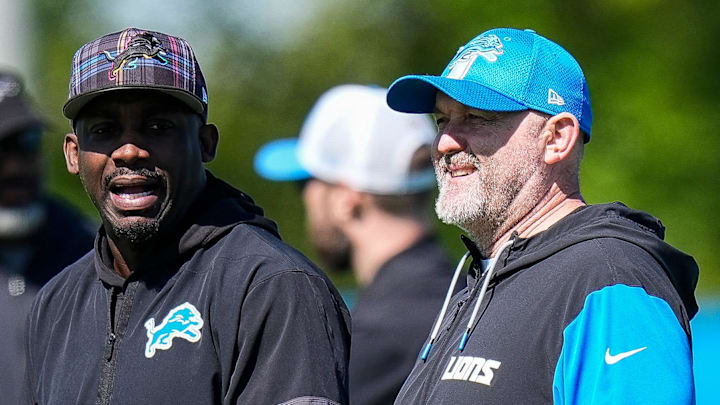 Detroit Lions assistant head coach and wide receivers coach Scottie Montgomery, left, talk to OC John Morton 