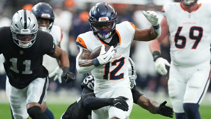 Dec 7, 2025; Paradise, Nevada, USA; Denver Broncos running back RJ Harvey (12) carries the ball as. Las Vegas Raiders safety Lonnie Johnson Jr. (32) defends during the first half at Allegiant Stadium. Dec 7, 2025; Paradise, Nevada, USA; Denver Broncos running back RJ Harvey (12) carries the ball as. Las Vegas Raiders safety Lonnie Johnson Jr. (32) defends during the first half at Allegiant Stadium.