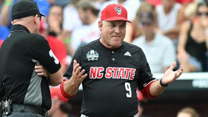 Jun 15, 2024; Omaha, NE, USA;  NC State Wolfpack head coach Elliott Avent discusses a balk call with an umpire in the game against the Kentucky Wildcats during the eighth inning at Charles Schwab Field Omaha. Mandatory Credit: Steven Branscombe-Imagn Images