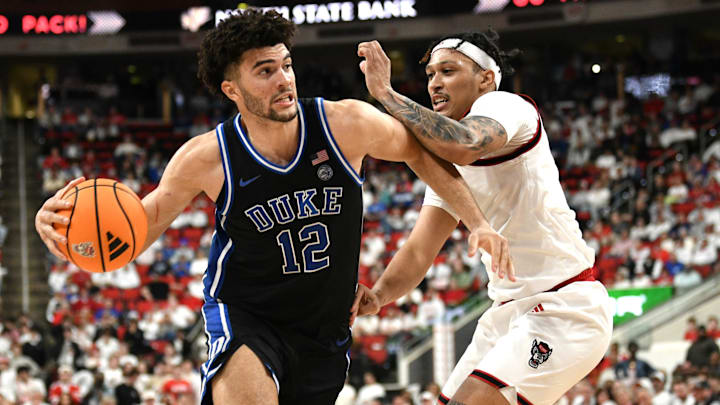 Mar 2, 2026; Raleigh, North Carolina, USA;  Duke Blue Devils forward Cameron Boozer (12) drives the ball around NC State Wolfpack forward Darrion Williams (1) during the first half at Lenovo Center. Mandatory Credit: Zachary Taft-Imagn Images