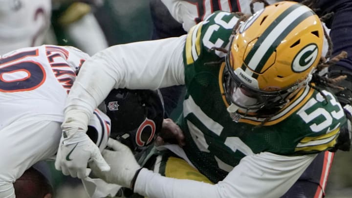 Chicago Bears quarterback Caleb Williams (18) evades a sack by Green Bay Packers defensive end Arron Mosby.