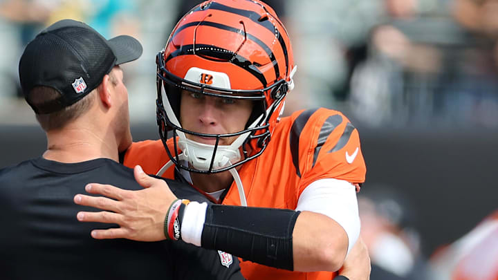 Sep 14, 2025; Cincinnati, Ohio, USA;  Cincinnati Bengals quarterback Joe Burrow (9) greets a coach before the game against the Jacksonville Jaguars at Paycor Stadium. Mandatory Credit: Joseph Maiorana-Imagn Images