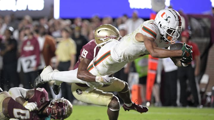 Oct 4, 2025; Tallahassee, Florida, USA; Miami Hurricanes wide receiver CJ Daniels (7) scores a touchdown against Florida State Seminoles defensive back Earl Little Jr. and defensive back Jerry Wilson (19) during the second half at Doak S. Campbell Stadium. Mandatory Credit: Melina Myers-Imagn Images