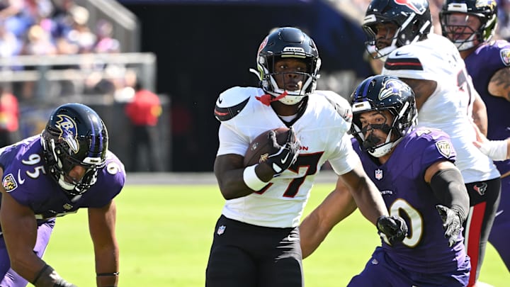 Oct 5, 2025; Baltimore, Maryland, USA; Houston Texans running back Woody Marks (27) runs for a gain past Baltimore Ravens linebacker Tavius Robinson (95) and linebacker Teddye Buchanan (40) during the first quarter at M&T Bank Stadium. Mandatory Credit: Rafael Suanes-Imagn Images