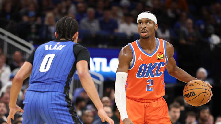 Dec 19, 2024; Orlando, Florida, USA; Oklahoma City Thunder guard Shai Gilgeous-Alexander (2) controls the ball from Orlando Magic guard Anthony Black (0) in the third quarter at Kia Center. Mandatory Credit: Nathan Ray Seebeck-Imagn Images